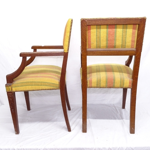 1926 - A pair of French oak elbow chairs, with studded upholstery, on tapered legs