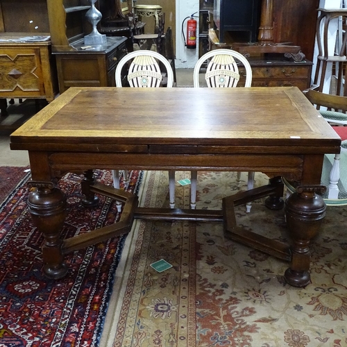 1927 - A rectangular oak draw leaf dining table, with carved frieze, baluster turned legs, and shaped stret... 