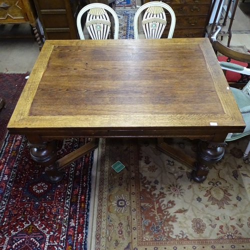 1927 - A rectangular oak draw leaf dining table, with carved frieze, baluster turned legs, and shaped stret... 