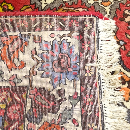 1947 - A handmade red ground Heriz wool rug, 300cm x 204cm