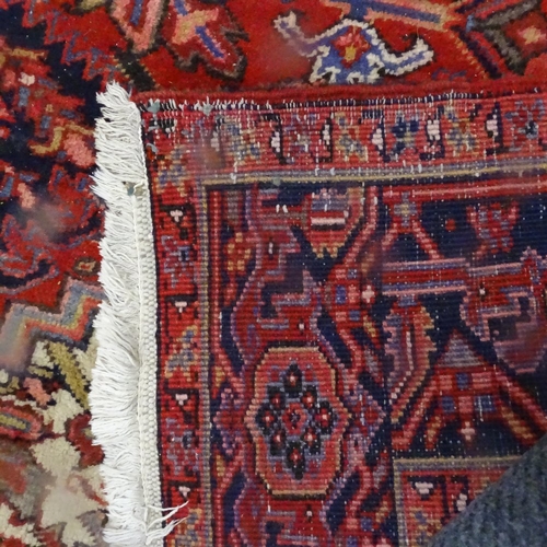 1975 - A red ground Kashan design carpet, with symmetrical lozenge and borders, 330cm x 238cm