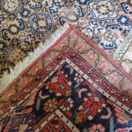 1977 - A red ground Tabriz design carpet, with symmetric pattern borders, 335cm x 225cm