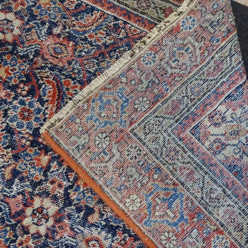 1869 - An Antique red and blue ground Persian rug, with symmetrical lozenge and borders, 180cm x 115cm