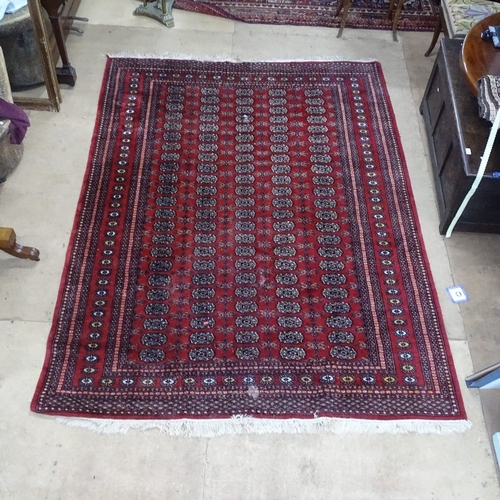 1871 - A red ground Afghan carpet, with gul lozenge and symmetrical borders, 255cm x 190cm