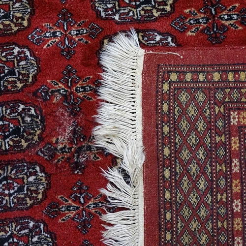 1871 - A red ground Afghan carpet, with gul lozenge and symmetrical borders, 255cm x 190cm