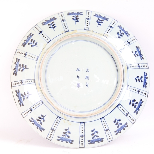 31 - A very large Chinese blue and white charger, allover floral decoration with 6 character mark on base... 