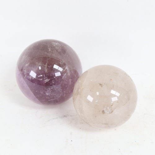 98 - A polished amethyst sphere crystal ball, and a smaller rock crystal example, largest diameter 10cm (... 