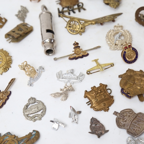 184 - Various military cap badges and brooches, including the Wiltshire Regiment, British Legion, and a Mi... 