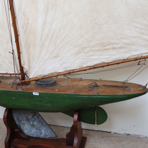 286 - A large 19th century green painted wooden hulled model pond yacht, with sails and rigging, hull leng... 