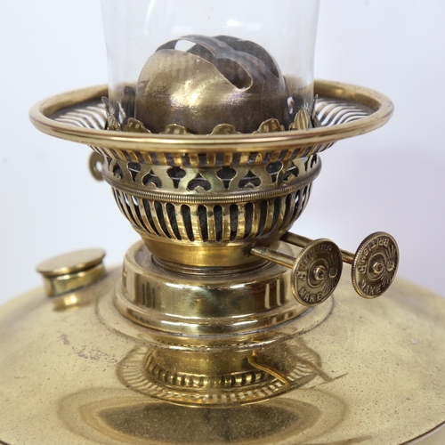 317 - A Vintage embossed brass oil lamp on black ceramic base, with glass chimney, height to fitting 32cm