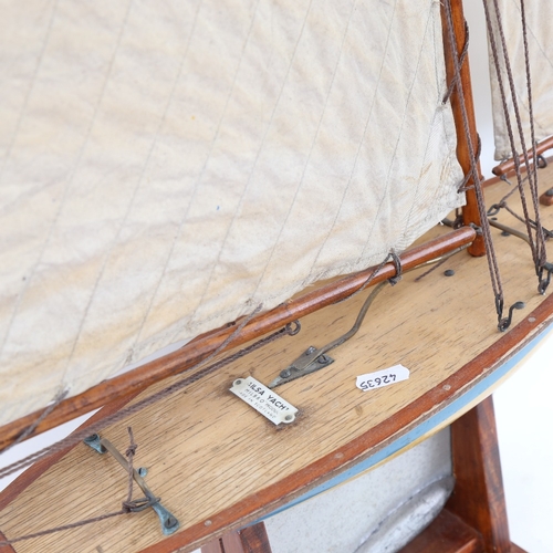 442 - A Vintage tin-hulled Ailsa pond yacht, with sails and rigging, hull length 47cm, with stand