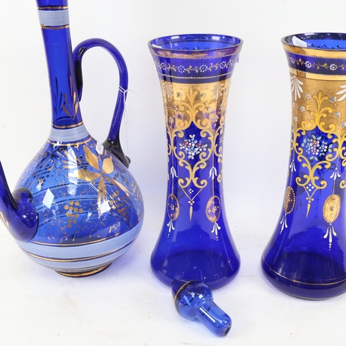 486 - A large gilded and painted Bristol blue glass ewer and matching pair of vases, ewer height 49cm (3)