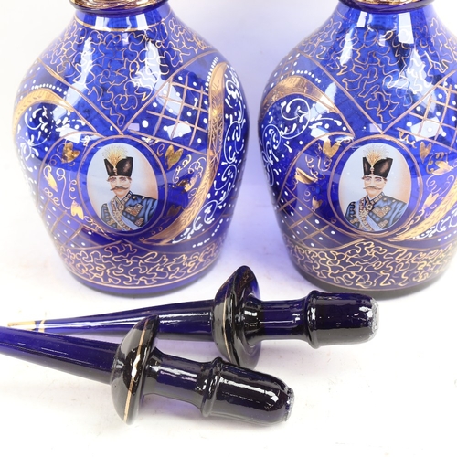 656 - A pair of gilded blue glass Ottoman style large decanters, with portrait panels, largest height 57cm