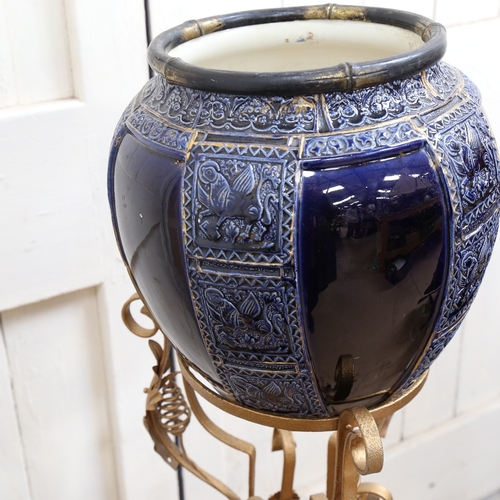 914 - A gold painted wrought-iron jardiniere stand, with blue glazed jardiniere, stand height 86cm