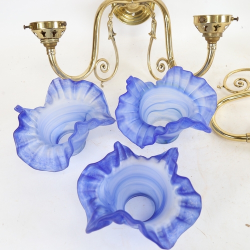 962 - A Christopher Wray brass twin-branch wall light fitting, with frilled blue glass shades, and a match... 