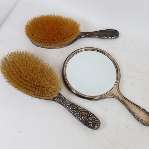 1274 - 2 silver-backed dressing table hair brushes, and a silver hand mirror (3)