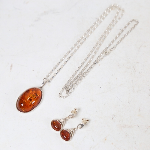 1317 - A matching silver-mounted amber pendant necklace and earring set