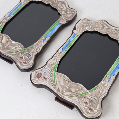 1328 - A pair of Art Nouveau style Continental silver and enamel-fronted strut photo frames, overall height... 