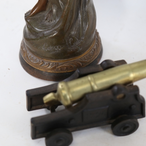 269 - An Art Nouveau spelter figure of a lady, and an iron and brass table cannon (2)