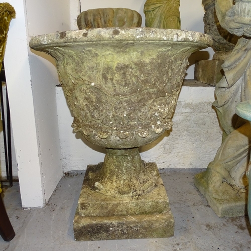 2217 - A large weathered embossed concrete garden urn, on square plinth, W63cm, overall height 70cm