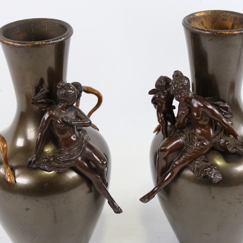 201 - A pair of 19th century patinated metal vases, surmounted by bronze Classical figures and gilded hand... 