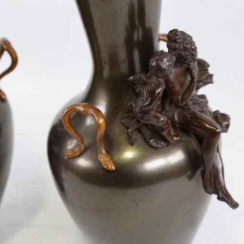201 - A pair of 19th century patinated metal vases, surmounted by bronze Classical figures and gilded hand... 