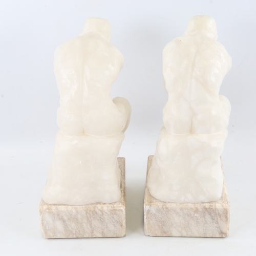 106 - A pair of carved alabaster crouching figures on marble block plinths, height 29cm