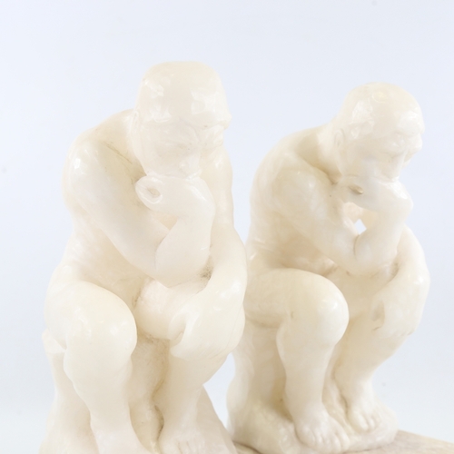 106 - A pair of carved alabaster crouching figures on marble block plinths, height 29cm