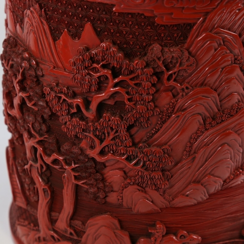 124 - A large Chinese cinnabar lacquer pot of cylindrical form, relief moulded mountain landscape designs,... 