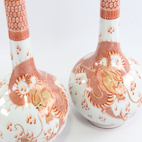 151 - A pair of Chinese white glaze porcelain bottle vases, with hand painted iron red and gilt dragons an... 