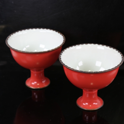 158 - A pair of Chinese coral glaze porcelain stemmed bowls, with white glaze interior and metal rims, 6 c... 