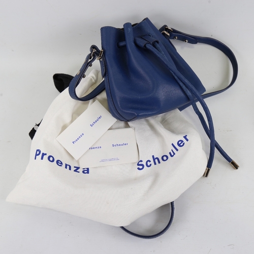 172 - PROENZA - a small dark blue leather handbag with shoulder strap and dust bag, height 15cm