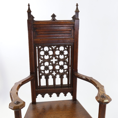 184 - A Victorian Gothic hall chair, carved and pierced Gothic tracery panelled back and curved arms, seat... 