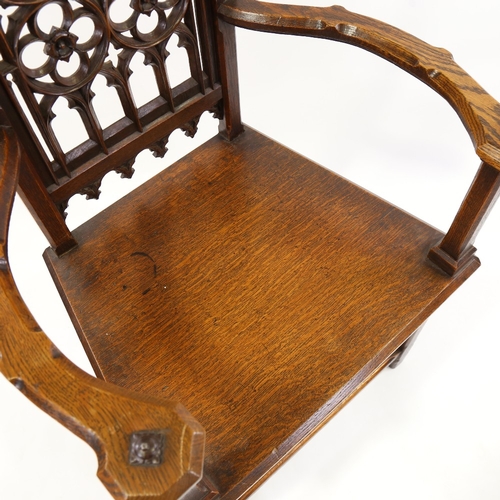 184 - A Victorian Gothic hall chair, carved and pierced Gothic tracery panelled back and curved arms, seat... 