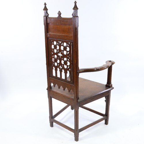 184 - A Victorian Gothic hall chair, carved and pierced Gothic tracery panelled back and curved arms, seat... 