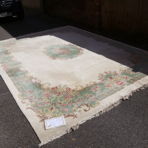 448 - A large Nepalese cream ground wool rug, floral centre and border, 410cm x 298cm