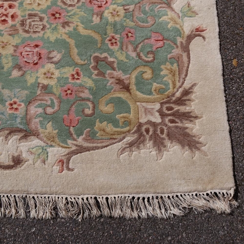 448 - A large Nepalese cream ground wool rug, floral centre and border, 410cm x 298cm