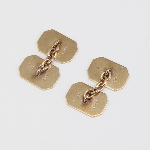 1118 - A pair of 9ct gold cufflinks, canted rectangular form with engine turned decoration, panel length 16... 