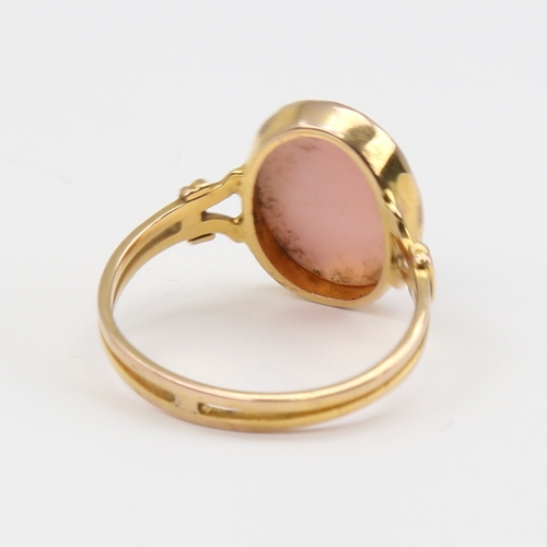 1119 - An unmarked gold relief carved pink coral cameo ring, depicting female profile, setting height 16mm,... 