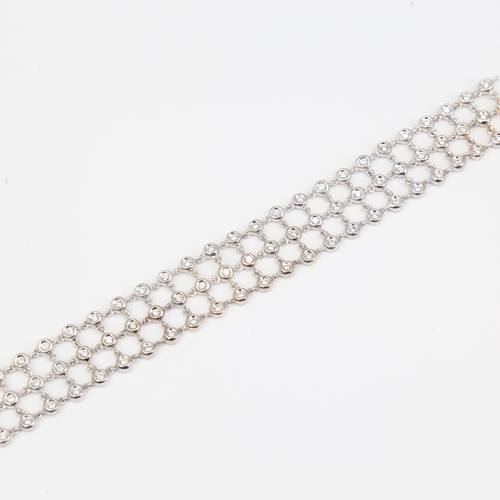 1130 - A modern 18ct white gold diamond triple-line bracelet, set with modern round brilliant-cut diamonds,... 