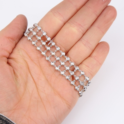 1130 - A modern 18ct white gold diamond triple-line bracelet, set with modern round brilliant-cut diamonds,... 