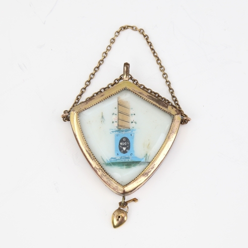 1138 - A Victorian unmarked yellow metal mourning pendant, shield form with bevel-glass panels and padlock ... 