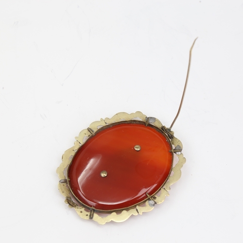 1139 - A large Victorian oval mourning brooch, unmarked yellow metal settings with red banded agate and vac... 