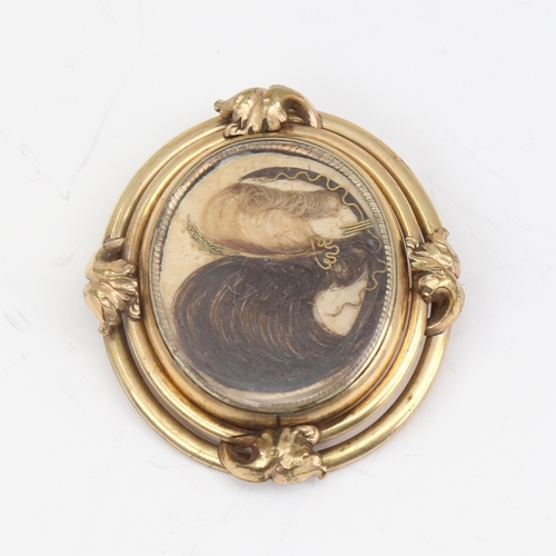 1140 - A large Victorian oval swivel mourning brooch, unmarked yellow metal frame with hair and braid panel... 