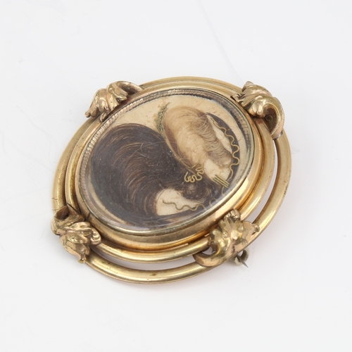 1140 - A large Victorian oval swivel mourning brooch, unmarked yellow metal frame with hair and braid panel... 