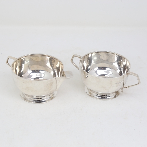 1157 - An Art Deco silver matching cream jug and sugar bowl, circular form with geometric handles, by Josia... 