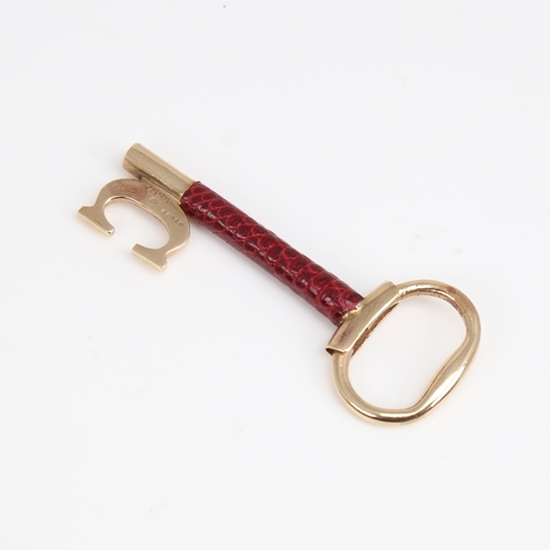 1192 - CARTIER - a Vintage 9ct gold and red leather key pendant, signed and numbered 76961, hallmarks Londo... 