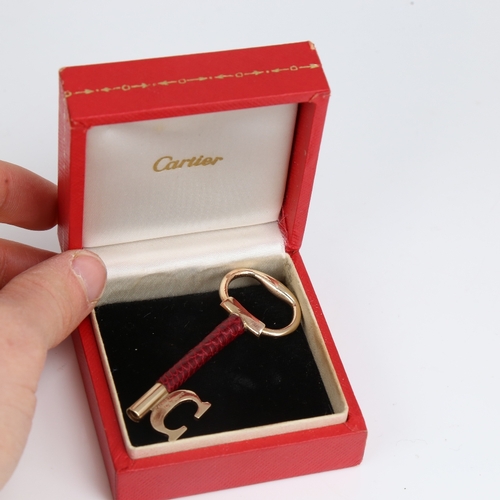 1192 - CARTIER - a Vintage 9ct gold and red leather key pendant, signed and numbered 76961, hallmarks Londo... 