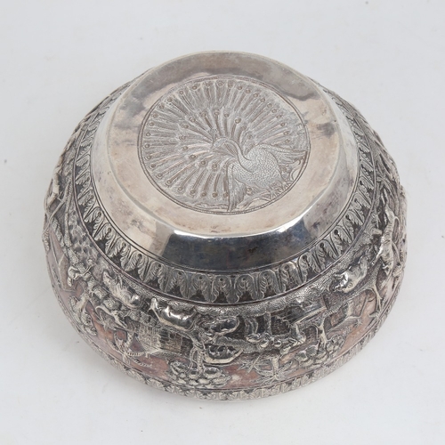 1200 - An early 20th century large Burmese silver rice bowl, relief embossed lion hunting and village scene... 