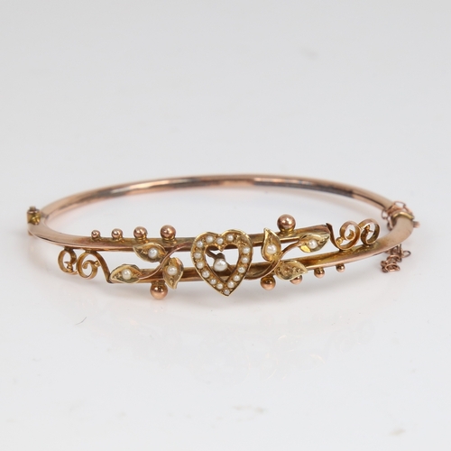 1204 - An early 20th century 9ct gold split-pearl heart and floral hinged bangle, hallmarks Chester 1905, s... 